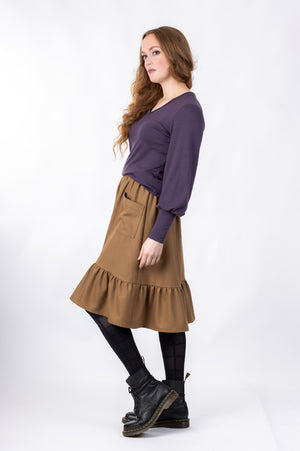 Forget-Me-Not Ella knee-length skirt pattern with pocket in brown, full-length side view of model 